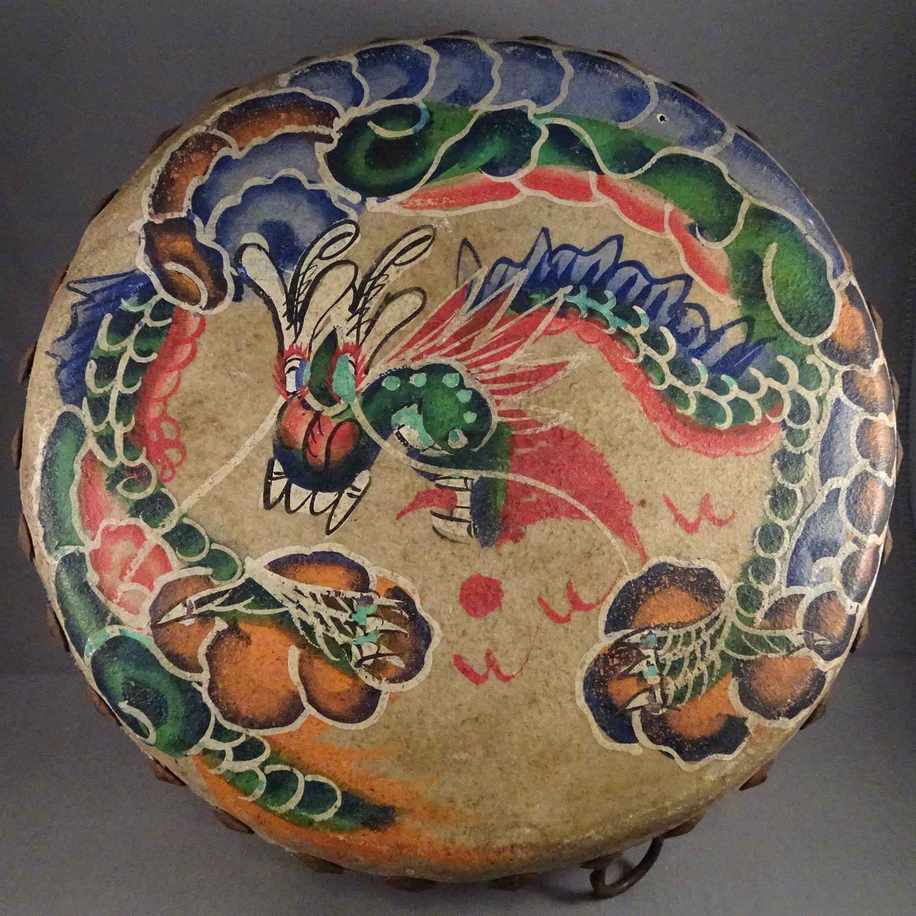 Chinese low war drum, with multi-coloured, stylised Dragon painted curled around on the skin. its head, with prominent teeth, in the middle.